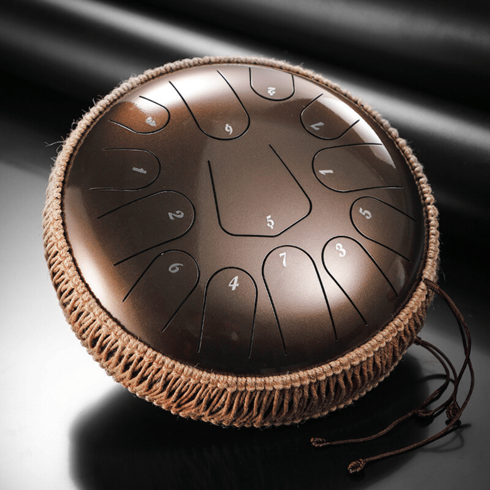 A 12-inch Hluru Steel Tongue Drum with 13 notes in C Major scale, featuring numbers on the surface, a protective varnish finish, and a textured edge.